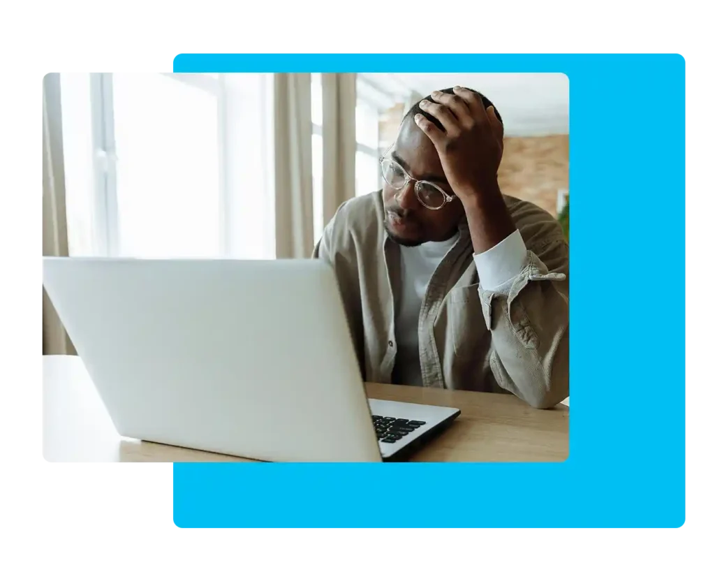 An African American man sitting at a computer frustrated.